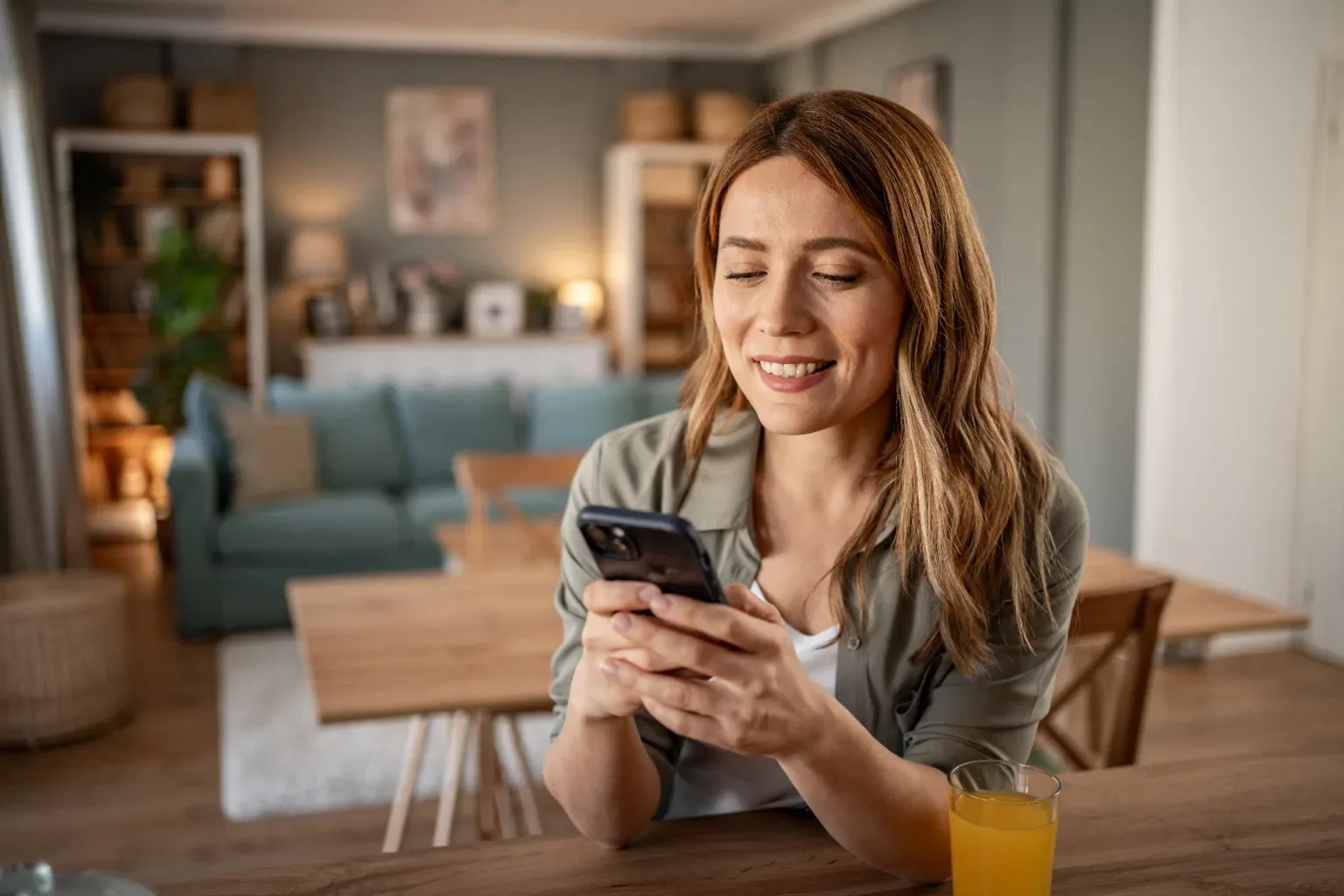Mujer sonriendo mientras usa su celular